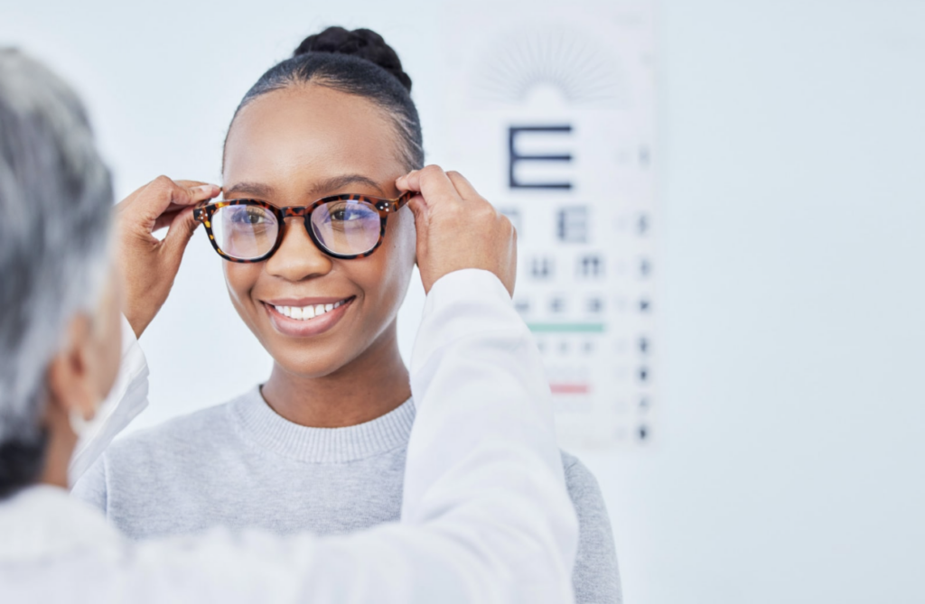 An optometrist adjusting a new pair of glasses for a female patient
